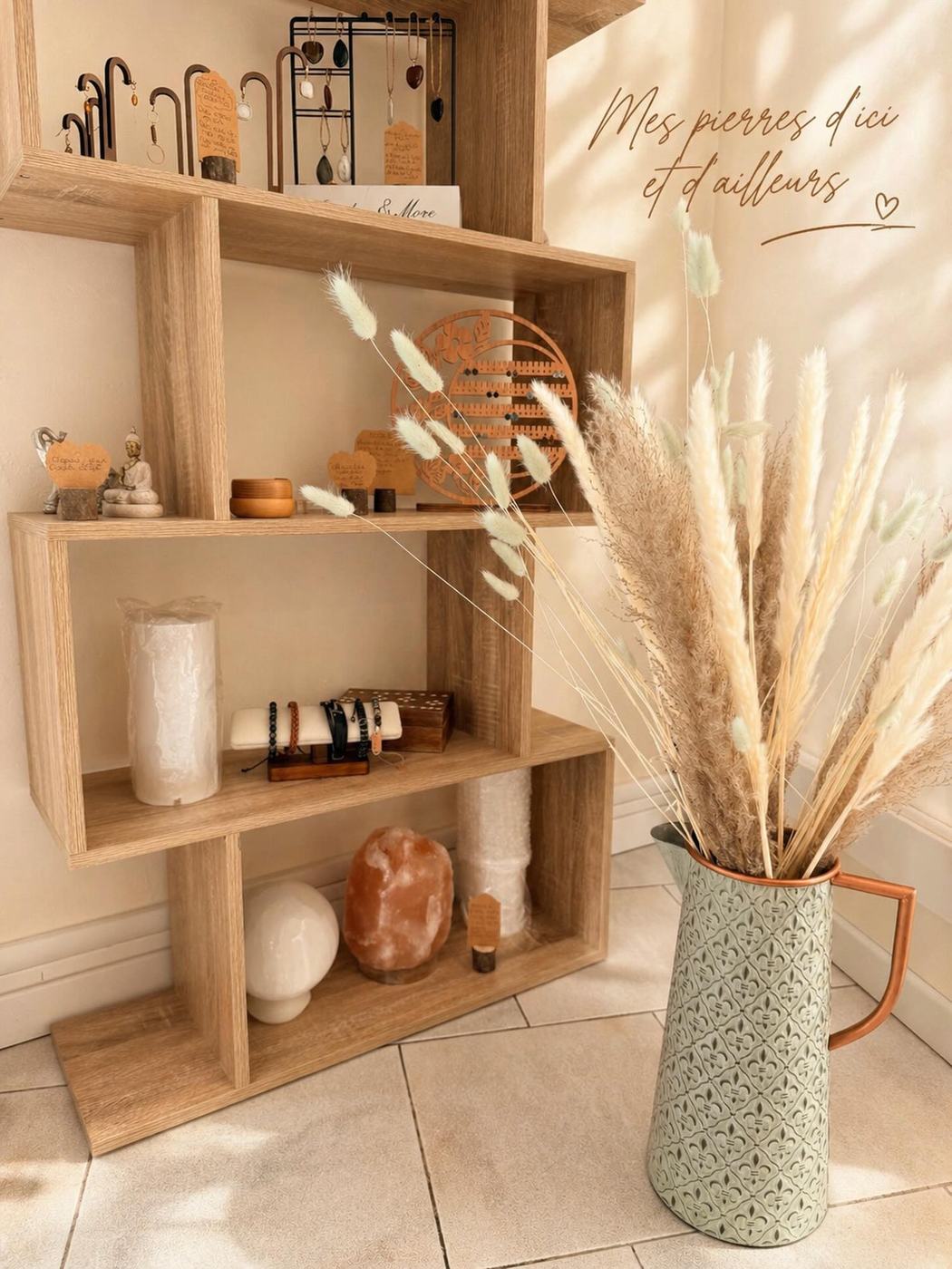 Étagère en bois clair avec lampe de sel, pampas et bracelets